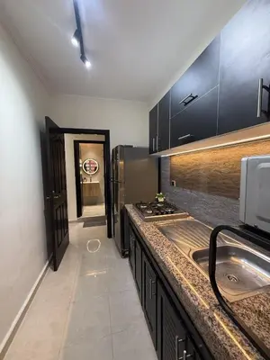 a kitchen with black cabinets and a counter top at Appartement chic près de Guéliz Calme & confort à Marrakech in Marrakech