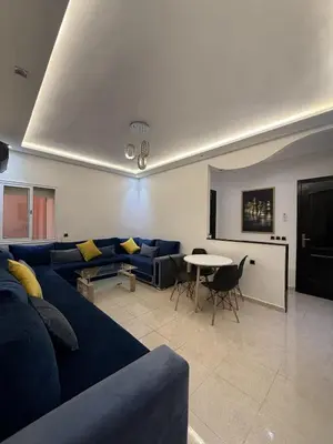 a living room with a blue couch and a table at Appartement chic près de Guéliz Calme & confort à Marrakech in Marrakech
