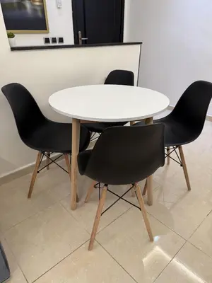 a white table with four black chairs around it at Appartement chic près de Guéliz Calme & confort à Marrakech in Marrakech