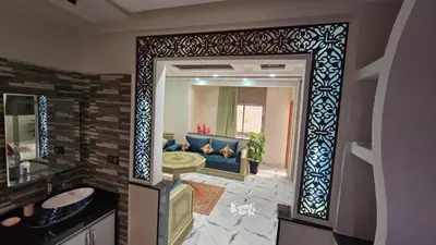 a living room with a blue couch and a mirror at Near Airport hosting in Marrakech