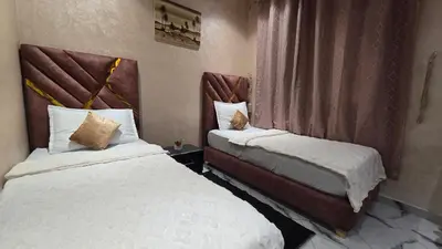 a hotel room with two beds and a window at Near Airport hosting in Marrakech