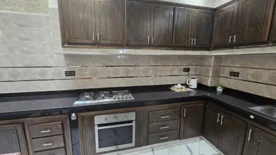 a kitchen with wooden cabinets and a stove at Near Airport hosting in Marrakech