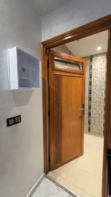 a wooden door in a room with a microwave at Near Airport hosting in Marrakech