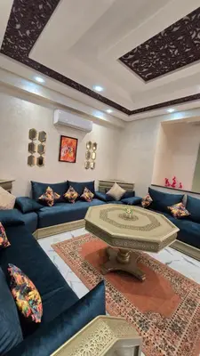 a living room with blue couches and a table at Near Airport hosting in Marrakech