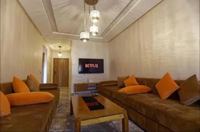 a living room with two couches and a tv at Appartement Marrakech 2 Chambres De Luxe Marron in Marrakech