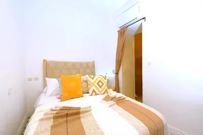 a bedroom with a bed with orange and white pillows at Riad Zellige in Marrakech