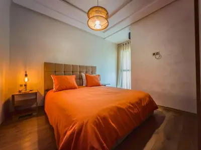 a bedroom with a large bed with orange pillows at Appartement Marrakech 2 Chambres De Luxe Orange in Marrakech