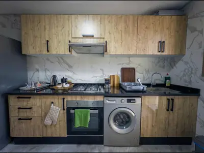a kitchen with a stove and a washing machine at Appartement Marrakech 2 Chambres De Luxe Orange in Marrakech