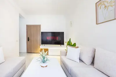 a living room with a couch and a tv at Luxueux appartement in Marrakech