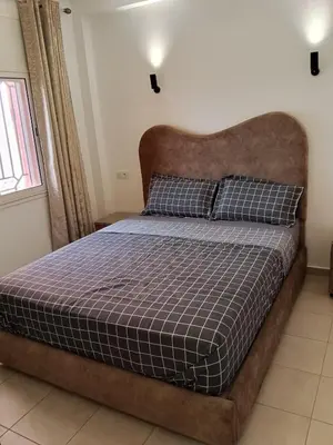 a bedroom with a large bed with a brown headboard at Appartement Marrakech in Marrakech