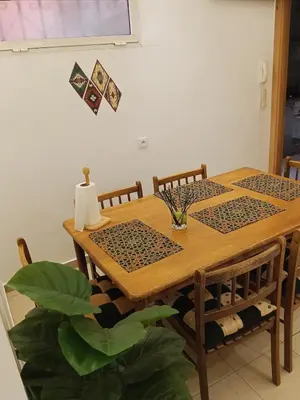 a dining room table with two chairs and a table with a plant at Appartement Marrakech in Marrakech
