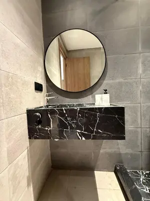 a bathroom with a mirror and a black counter at New apartment in Jnane El Guéliz in Marrakech