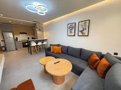 a living room with a blue couch and a table at T3 élégant 2ch piscine chauffée & fitness in Marrakech