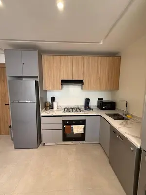 a kitchen with a refrigerator and a stove top oven at T3 élégant 2ch piscine chauffée & fitness in Marrakech