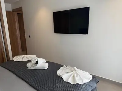 a room with two towels on a bed with a television at T3 élégant 2ch piscine chauffée & fitness in Marrakech