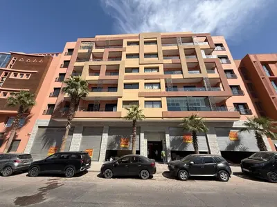 a large building with cars parked in front of it at T3 élégant 2ch piscine chauffée & fitness in Marrakech