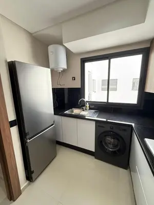 a kitchen with a refrigerator and a washing machine at Appartement centre ville Marrakech avec Piscine in Marrakech