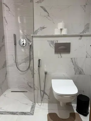 a white bathroom with a shower and a toilet at Appartement centre ville Marrakech avec Piscine in Marrakech