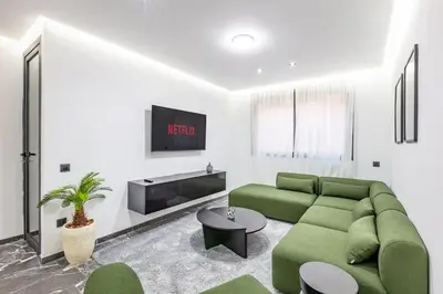 a living room with a green couch and a tv at Design, comfort and perfect location! in Marrakech