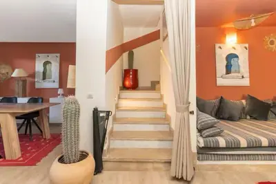 a living room with a staircase with a couch and a table at Villa luxueuse pour un séjour inoubliable in Marrakech