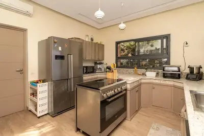 a kitchen with a stove and a refrigerator at Villa luxueuse pour un séjour inoubliable in Marrakech