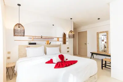 a bedroom with a large white bed with a red blanket on it at Architect's studio in the city center! in Marrakech