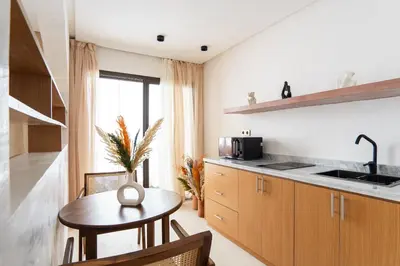 a kitchen with a table and a sink and a counter at Architect's studio in the city center! in Marrakech
