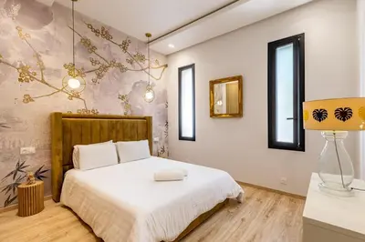 a bedroom with a bed with white sheets and a lamp at Villa Amelkis avec Piscine - 4 suites de luxe à Marrakech in Marrakech