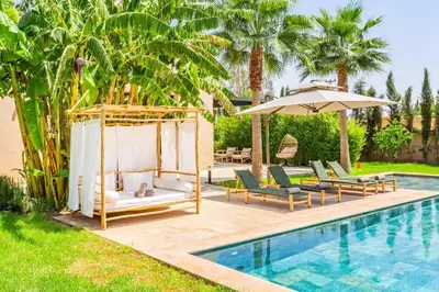 a pool with a swing and chairs and an umbrella at Villa Amelkis avec Piscine - 4 suites de luxe à Marrakech in Marrakech
