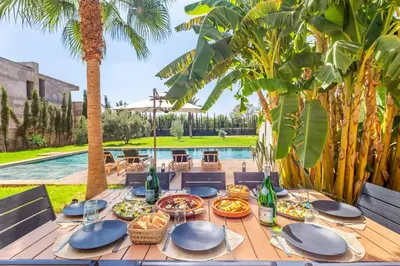 a table with food and drinks on a wooden deck at Villa Amelkis avec Piscine - 4 suites de luxe à Marrakech in Marrakech
