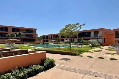 a courtyard with a swimming pool in a building at Cosy Apartment with Balcony and Pool in Noria Golf in Marrakech