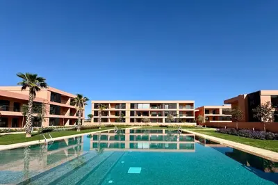 an empty swimming pool in front of a building at Cosy Apartment with Balcony and Pool in Noria Golf in Marrakech