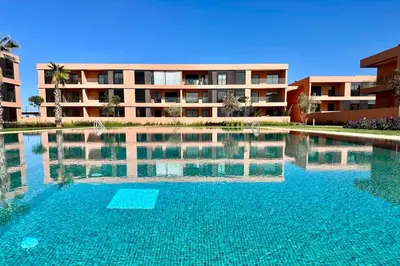 a large swimming pool in front of a building at Cosy Apartment with Balcony and Pool in Noria Golf in Marrakech