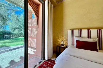 a bedroom with a bed and a large window at Two Bedroom Garden Apartment in Palmeraie 2 in Marrakech