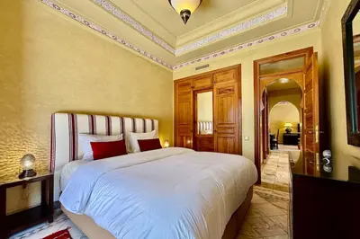 a bedroom with a large white bed with red pillows at Two Bedroom Garden Apartment in Palmeraie 2 in Marrakech