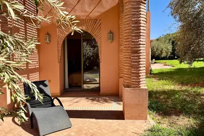 a bench sitting outside of a house at Two Bedroom Garden Apartment in Palmeraie 2 in Marrakech