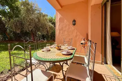 a table and chairs sitting on a patio at Two Bedroom Garden Apartment in Palmeraie 2 in Marrakech