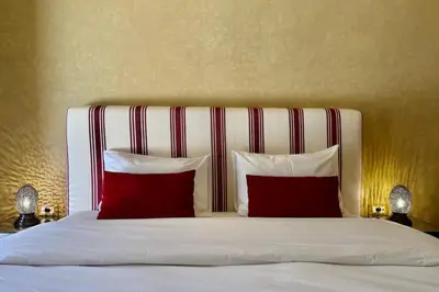 a bed with red and white pillows in a bedroom at Two Bedroom Garden Apartment in Palmeraie 2 in Marrakech