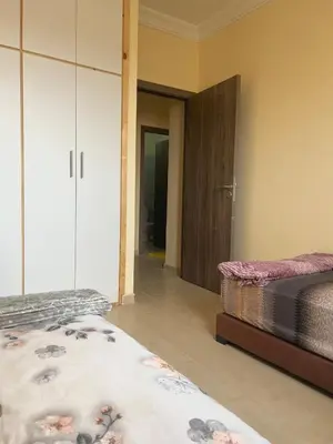 a bedroom with two twin beds and a closet at Apartment 5 minutes from the airport in Marrakech
