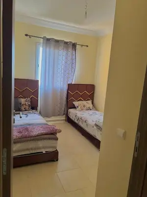 a bedroom with two beds and a window at Apartment 5 minutes from the airport in Marrakech