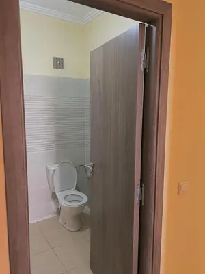 a bathroom with a toilet with a door open at Apartment 5 minutes from the airport in Marrakech