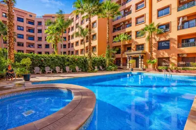 a swimming pool in front of a building at Royal Pool Apartment Hivernage Marrakech in Marrakech