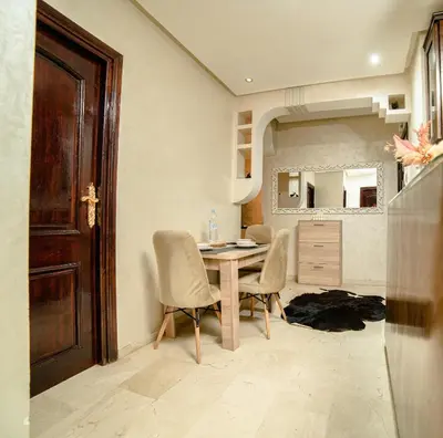 a dining room with a table and chairs and a mirror at Royal Pool Apartment Hivernage Marrakech in Marrakech