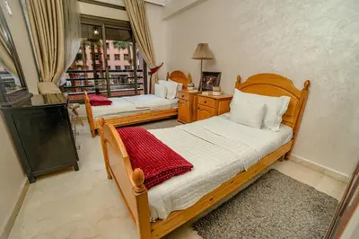 two wooden beds in a room with a window at Royal Pool Apartment Hivernage Marrakech in Marrakech