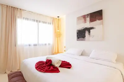 a white bed with two red towels on it at Refined studio in the city center! in Marrakech