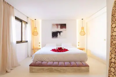 a bedroom with a white bed with a red flower on it at Refined studio in the city center! in Marrakech