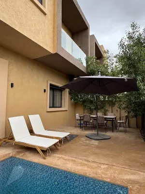 a patio with an umbrella and chairs and a table at Villa Aliya in Marrakech