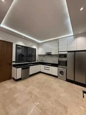 a large kitchen with white cabinets and a dishwasher at Villa Aliya in Marrakech