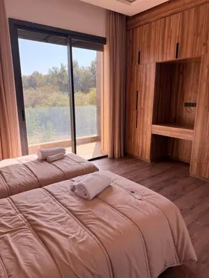 a bedroom with two beds and a large window at Villa Aliya in Marrakech