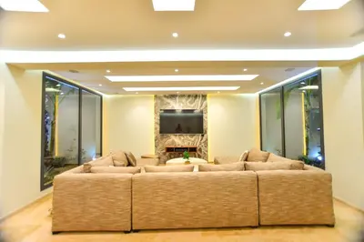 a living room with a large couch in front of a tv at Luxury villa with heated pool and Hamam in Marrakech